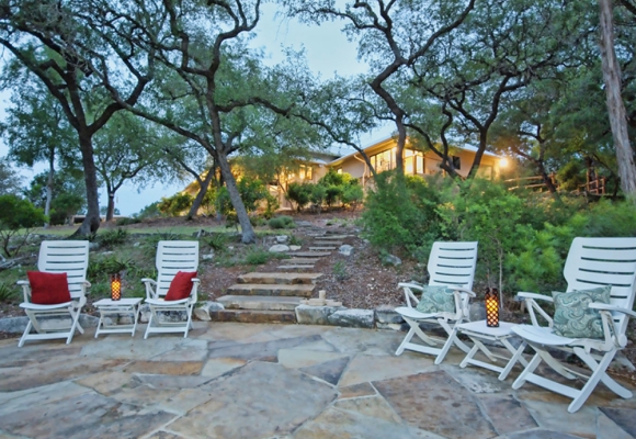Stone seating area near a fire pit off the back of a custom built on in the Central Texas Hill Country.