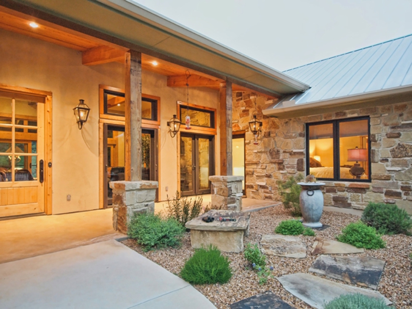 Entrance to a custom built ranch style home in Wimberley, Texas. Xeriscaped garden with native plants and stones.