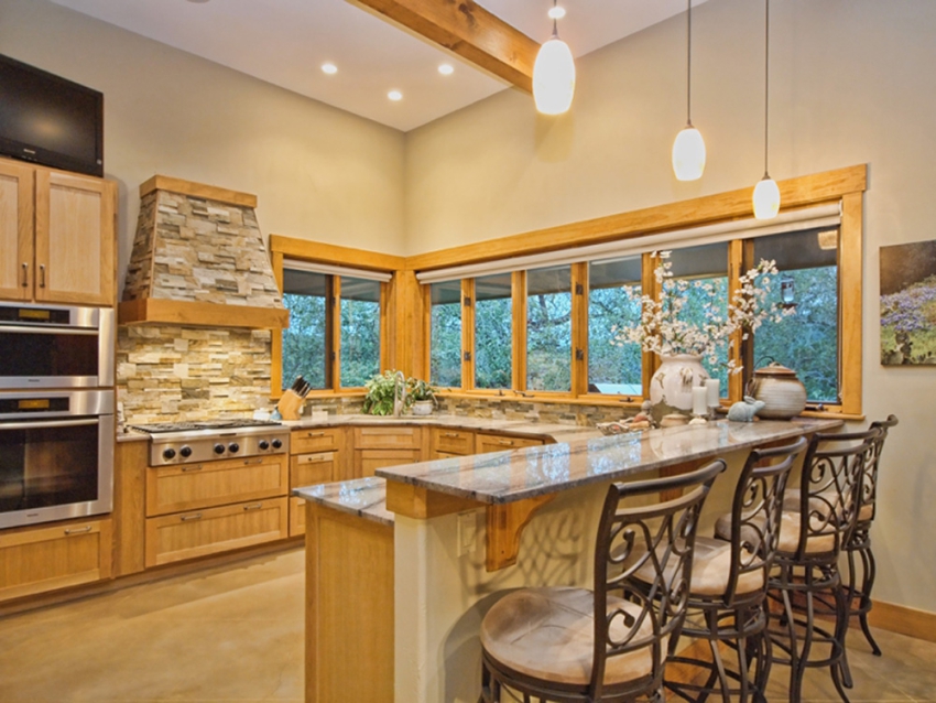 Large kitchen in a custom built ranch style home in Wimberley, Texas. Windows and sliding door opeing up the the Central Texas Hill Country.