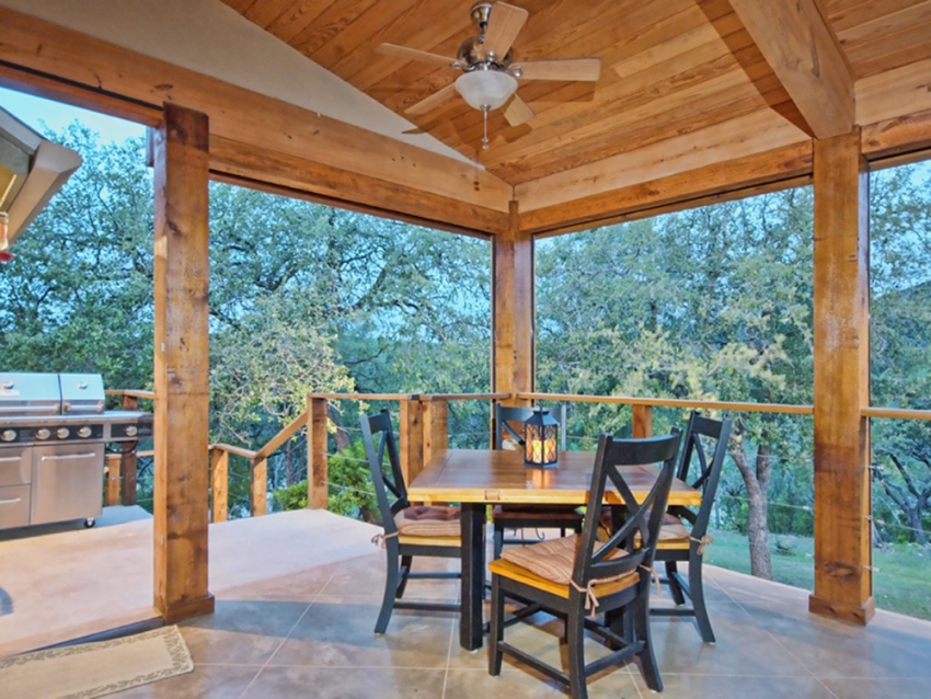 Covered patio with 4 chair dining table, and outdoor grill. Texas hill country outside of Wimberley. Custom built home by SB Thompson Construction and Contractors.