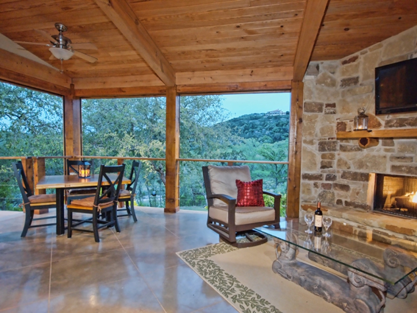 Covered patio with fireplace overlooking the Texas hill country outside of Wimberley. Custom built home by SB Thompson Construction and Contractors.
