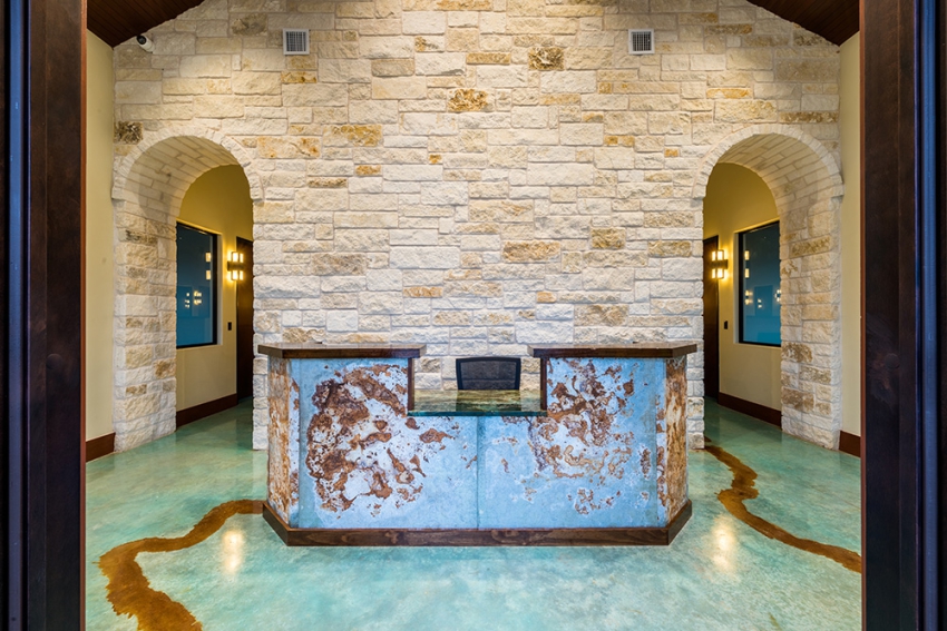 Commercial and Industrial Construction and Building Contractor, Lobby with limestone wall, gold and blue apoxy floor, and marble front receptionist desk with granite top.
