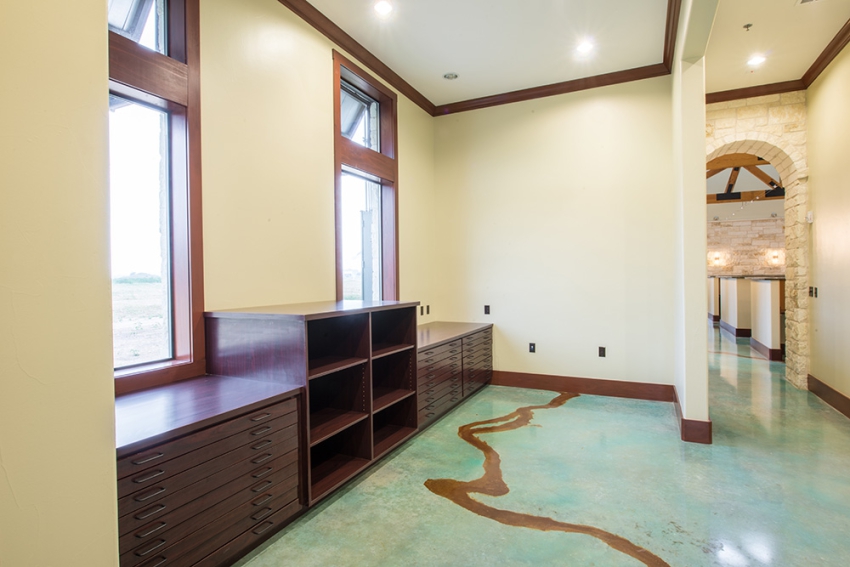 Commercial Construction, in Central Texas. built in dark wood cabinets and shelving, stone archway in hall and gold apoxy floor. SB Thompson Construction Contractors.