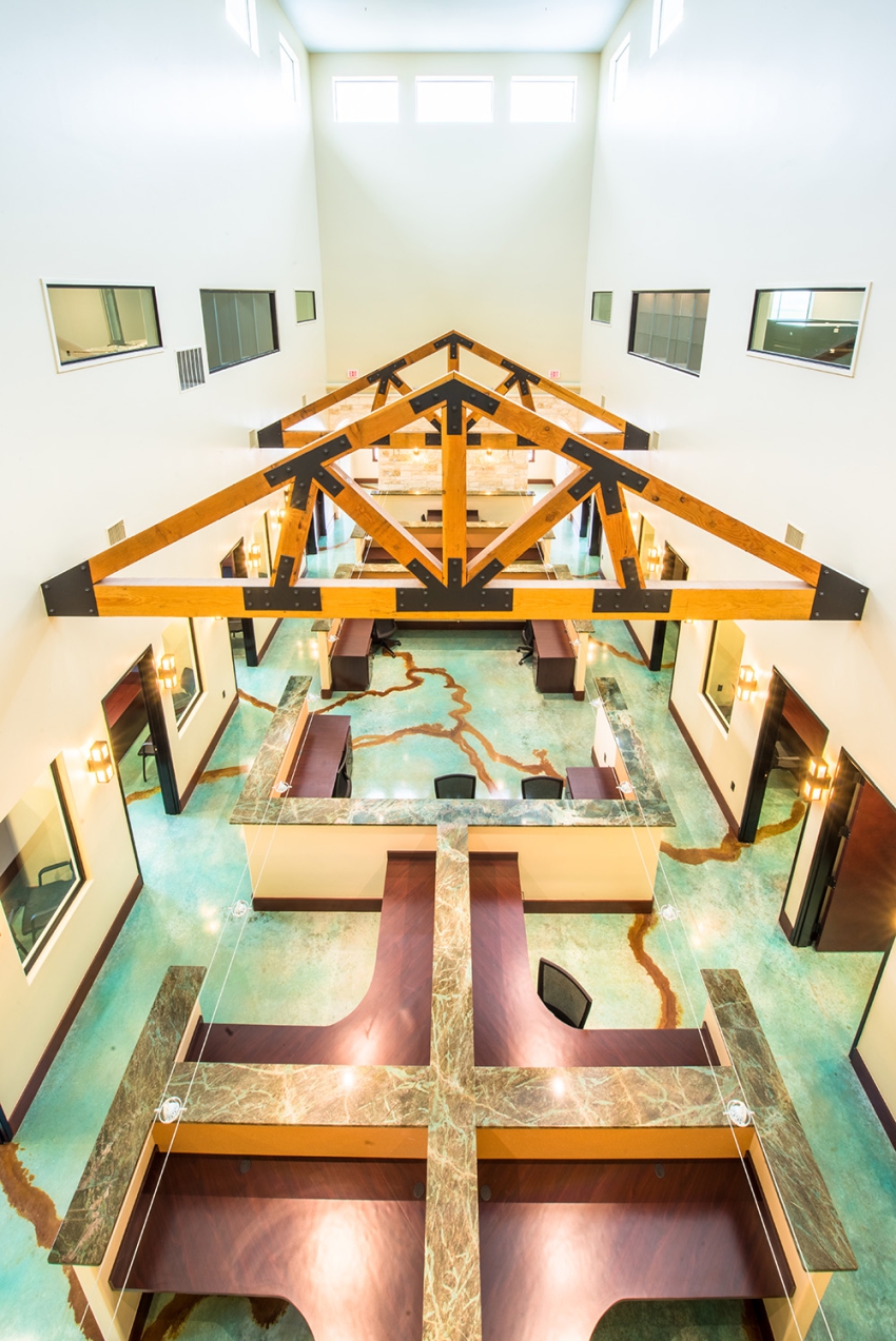 Commercial Construction, in Central Texas. Two story open layout with custom built in desks, granite counter tops, and a custom green, exposed beams, and gold apoxy floor.