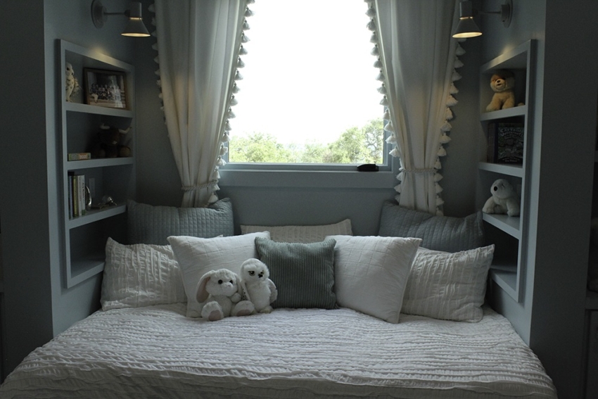 Bedroom nook in Custom home built in Wimberley, Texas by SB Thompson Construction. Built in blue shelving and bed under window.