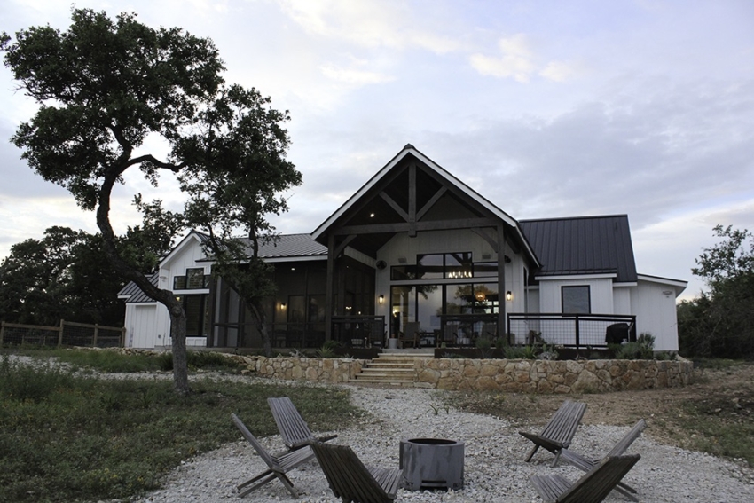 Custom Home black and white with rock wall, fire pit, and oak tree built by SB Thompson in Wimberley, Texas.