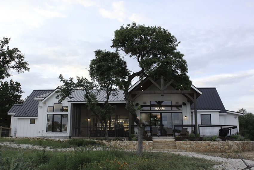 Custom Home black and white with rock wall and oak tree built by SB Thompson in Wimberley, Texas.