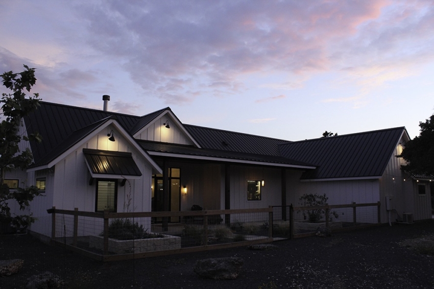 Custom Home modern farmhouse partial view of back with sunset. Built in Wimberley, Texas by S.B. Thompson Construction